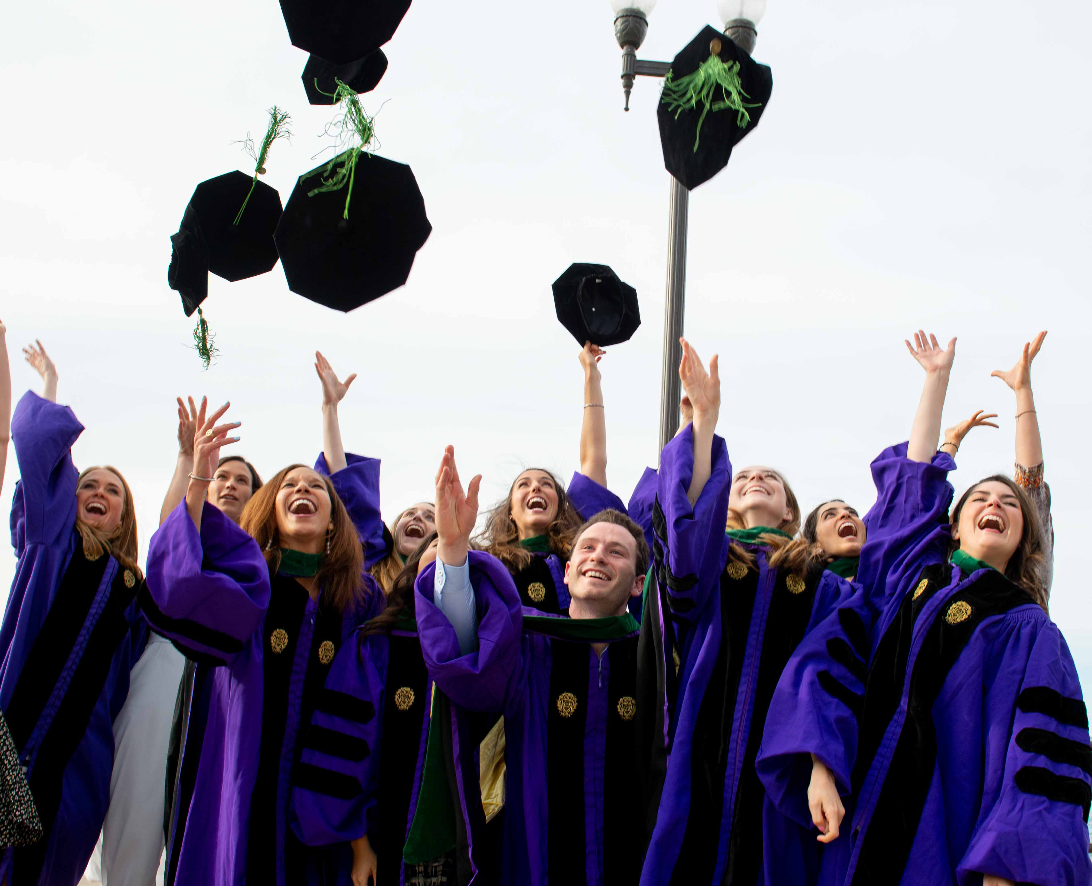 2019 Feinberg MD graduates throwing caps in the air.